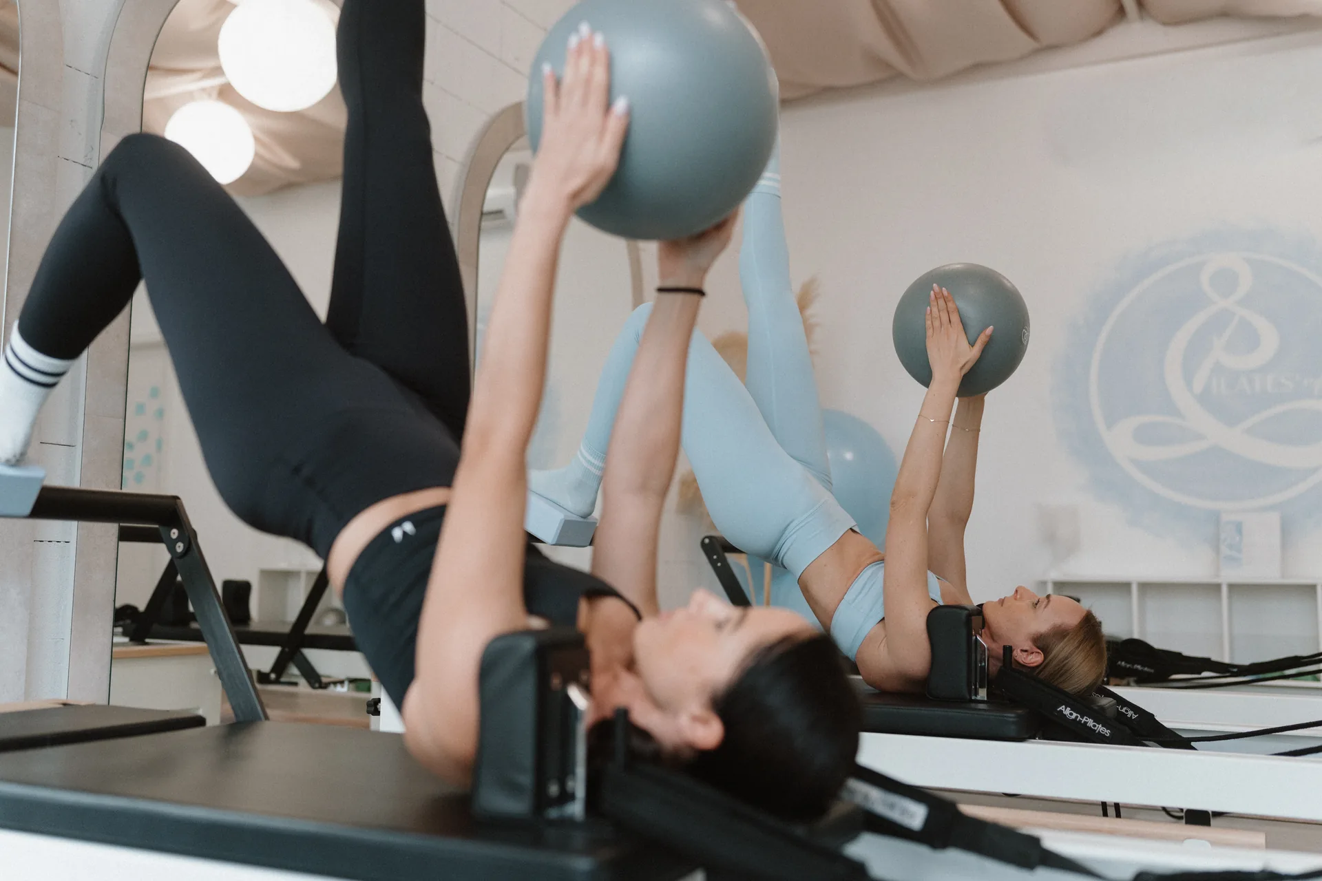 Reformer pilates medencefenék-koordinációs gyakorlat kis labdával, egy láb emelésben a Pilates’nfinity budaparti stúdióban.