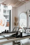Reformer pilates gépek a Pilates’nfinity Budapart stúdióban, nagy ablakokkal és tükrös, világos térben